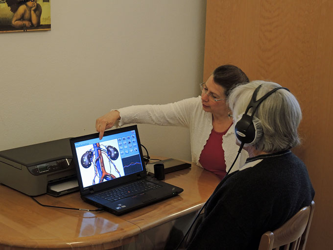 Foto einer Bioresoanz-Anwendung mit einer Patientin mit Kopfhörer und Therapeutin Sylvia Kahlert